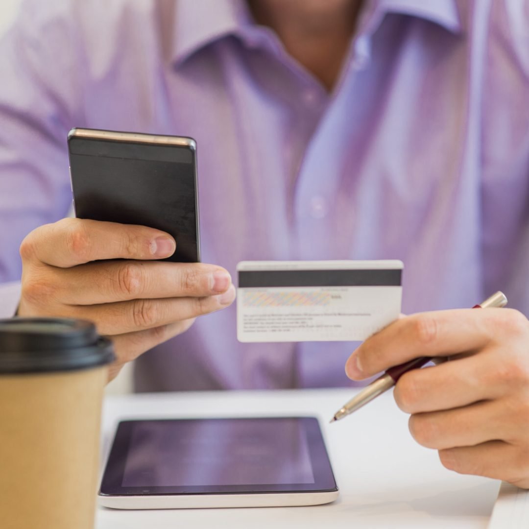 guy hand holding credit card, enjoying internet online shopping using digital computer tablet at home.